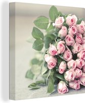 Canvas Schilderij Een grote boek van roze rozen ligt op een tafel. - 50x50 cm - Wanddecoratie
