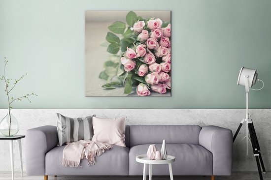 Un grand livre de roses roses repose sur une table Toile 90x90 cm - Tirage photo sur toile (Décoration murale salon / chambre) / Peintures Fleurs sur toile