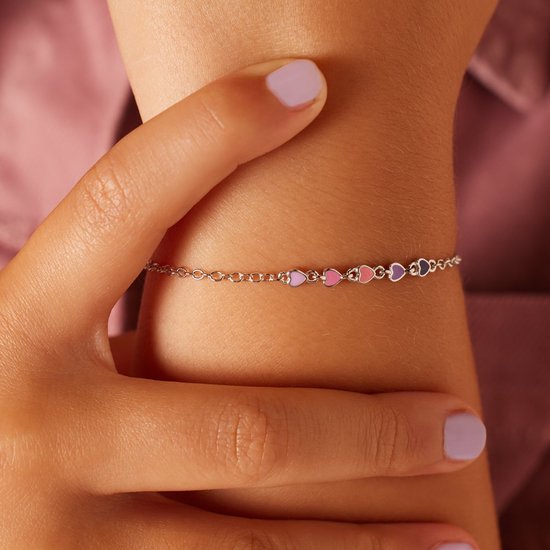 Close-up van een zilverkleurig armbandje met vijf kleine, gekleurde hartjes in roze en paars.