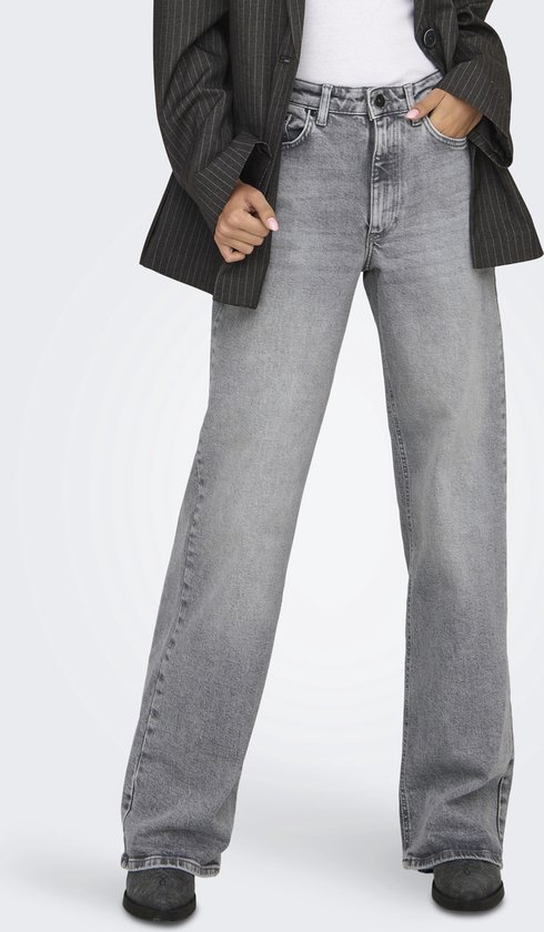 Model in een grijze jeans met wijde pijpen en een gestreepte blazer.