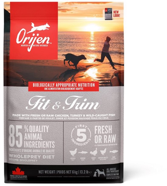 Orijen Fit & Trim hondenvoer zak met afbeelding van een vrouw en hond op het strand bij zonsondergang.