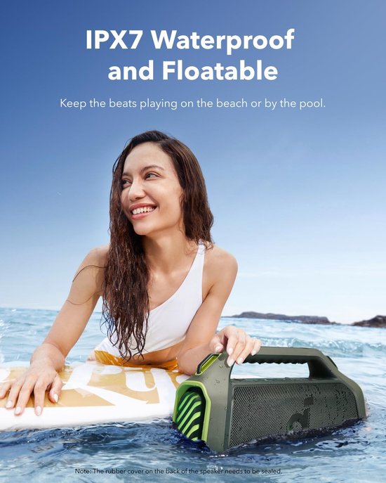 Vrouw op een surfplank in de zee met de groene speaker drijvend naast haar.