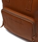 Close-up van het voorvak van een bruine leren rugzak met het logo 'The Chesterfield Brand'.