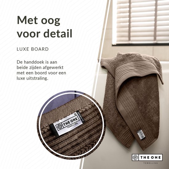 Bruine handdoek met luxe boord. Het "THE ONE" logo is zichtbaar.