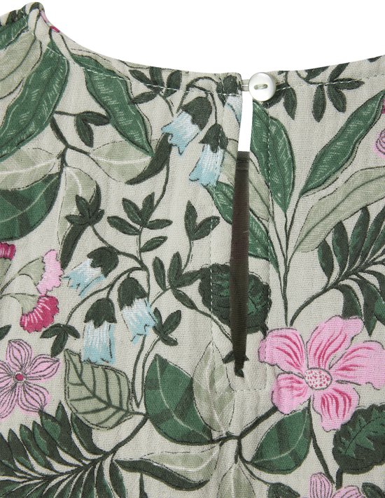 Detail van de lichtgroene blouse met bloemen- en bladerenprint, met knoopsluiting in de nek.