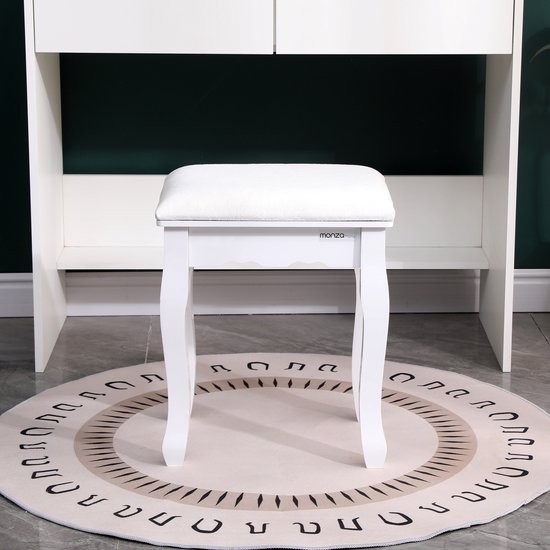 Witte kaptafelkruk met gestoffeerd zitvlak, onder een witte kaptafel.