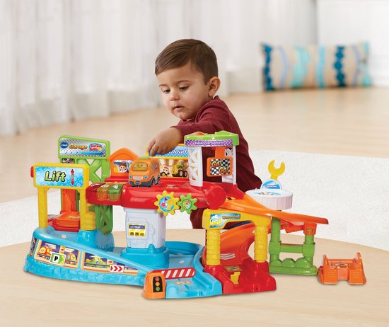 Een baby speelt met de VTech Toet Toet Auto's speelgoedgarage met auto's.