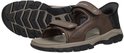 Bruine Skechers 'Slip-Ins' sandalen, één met zool omhoog, beide met klittenbandsluiting.