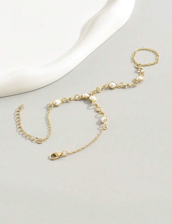 Gouden handketting met schakels, parels en witte steentjes.