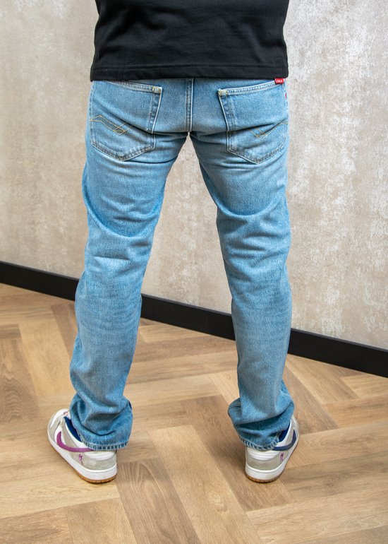 Homme en jean Replay bleu clair, le dos est visible. Le pantalon est une coupe regular.
