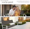 Een koppel op een donkerbruine tuinbank met wit frame, genietend van de zon.