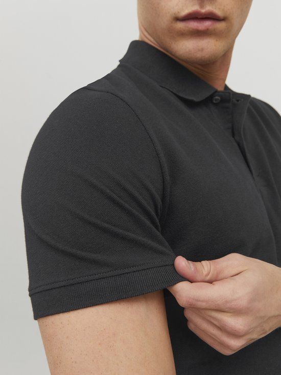 Donkergrijze poloshirt met korte mouwen, gedragen door een man. Detail van de polokraag en mouwboord.
