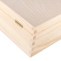 Detail van de hoek van een houten kist, met zichtbare scharnieren en zwaluwstaartverbindingen.