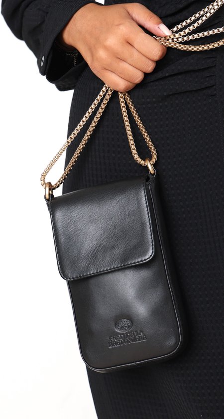 Model draagt een zwarte, verticale lederen tas met gouden schakelketting over de schouder. Logo met kroon en tekst 'FRED DE LA BRETONIERE'.