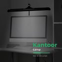 Zwarte bureaulamp boven een computer op een bureau. Kantoorsfeer.
