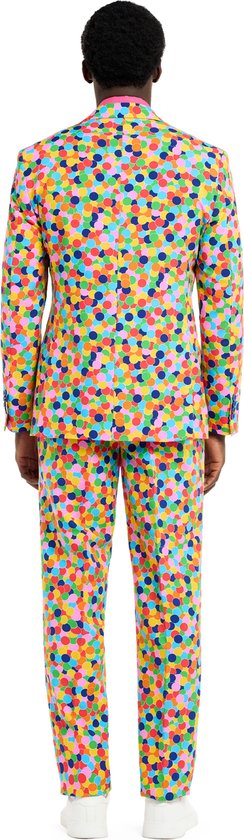 Man in een veelkleurig pak met confettiprint en roze shirt, achter-aanzicht.