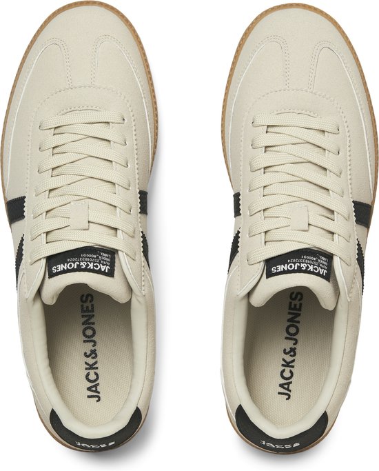 Bovenkant van crèmekleurige sneakers met veters, zwarte strepen en 'Jack & Jones' logo op de binnenzool.