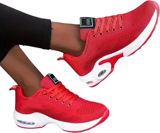 Basses baskets rouges à semelles blanches, portées par une femme. L'étiquette sur la languette indique 'FASHION'.