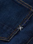 Detail van donkerblauwe jeansstof met gele en blauwe kruisstiksels op de zak.