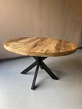Table à manger ronde avec plateau en bois et pied Matrix noir, sur sol gris.