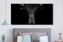 Toile noir et blanc d'un taureau au-dessus d'un lit, sur fond sombre.