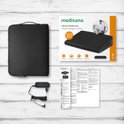 Medisana verwarmde wigkussen, adapter, en instructies op een witte houten achtergrond.