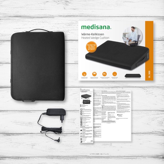 Medisana verwarmde wigkussen, adapter, en instructies op een witte houten achtergrond.