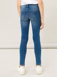 Kind draagt een blauwe skinny jeans, achterkant zichtbaar.