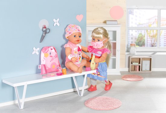Twee baby poppen met doktersaccessoires, waaronder maskers en thermometers.