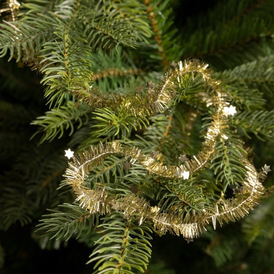 Guirlande de Noël dorée avec de petites étoiles, enroulée autour de branches de sapin vertes.