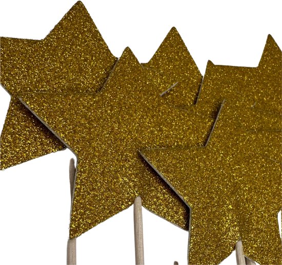 Gouden glitterster cocktailprikkers op zwarte achtergrond.