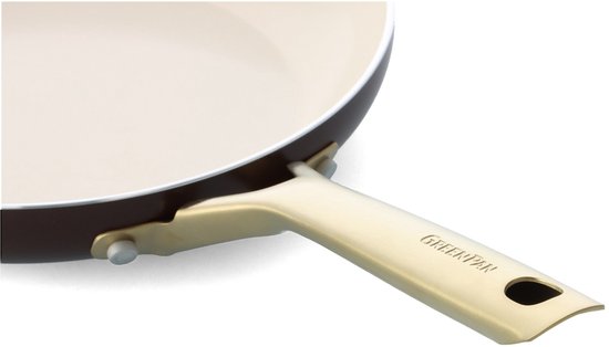 Detail van gouden handvat aan bruine koekenpan. "GREENPAN" logo zichtbaar.
