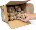 Een hand pakt een vetbol uit een open kartonnen doos gevuld met vetbollen. De zijkant van de doos toont een afbeelding van een koolmees.