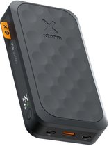 Zwarte Xtorm powerbank 20.000mAh met 35W, textuur met cirkels en oranje zijknop.