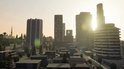 Stadsgezicht met hoge gebouwen, palmbomen en zonsondergang met de tekst VINEWOOD.