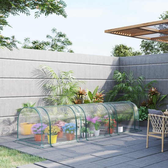 Een doorzichtige tunnelkas met groen frame, gevuld met potplanten, die op een betegelde patio wordt getoond.
