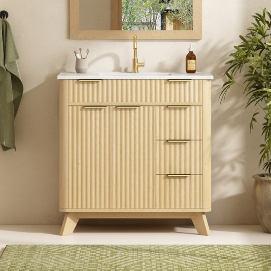 Natuurhouten badmeubel met golvend front, goudkleurige handgrepen en witte wastafel.