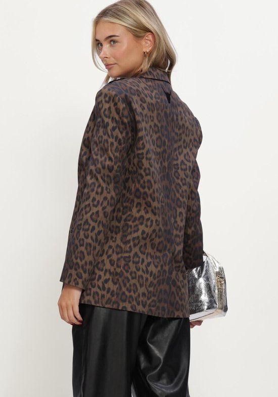 Model draagt een bruine blazer met luipaardprint, details in krijtstreep en een zilveren handtas.