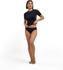 Model draagt een zwarte naadloze functionele sportset bestaande uit een T-shirt en een bijpassende sportonderbroek.