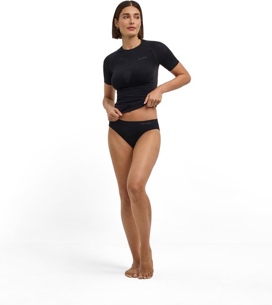 Model draagt een zwarte naadloze functionele sportset bestaande uit een T-shirt en een bijpassende sportonderbroek.
