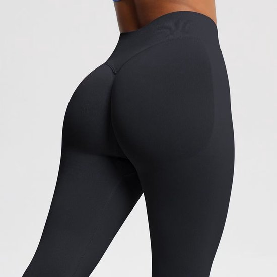 Detailopname achterzijde van zwarte sportlegging met scrunch-detail.