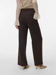 Model van achteren gezien, draagt een donkerbruine broek met wijde pijpen en een pinstreep. Draagt ook een beige kanten blouse.