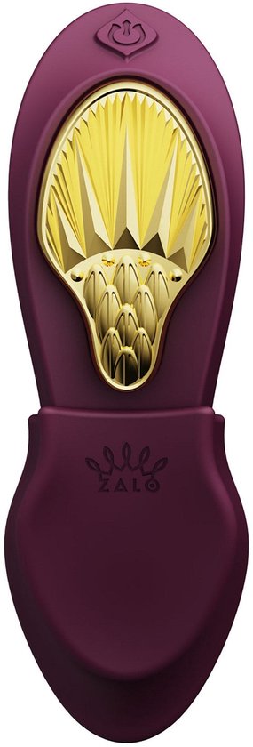 Vibrateur violet avec ornement doré sur le dessus.