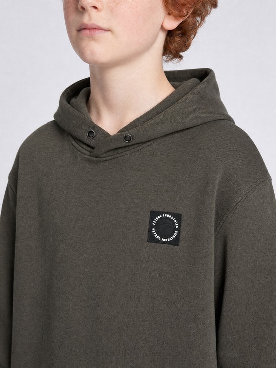 Jongen draagt een olijfgroene Petrol Industries hoodie met een rond zwart logolabel op de borst.