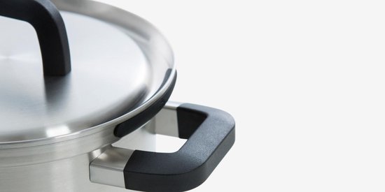 Close-up van de rand van een roestvrijstalen pan met een zwart handvat en deksel.