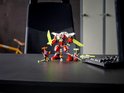 Rood-witte mech en minifiguren op een bureau, met gele zwaarden en accessoires.