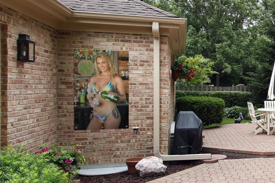 Poster van blonde vrouw in bikini aan bakstenen muur van een huis, tuin setting.