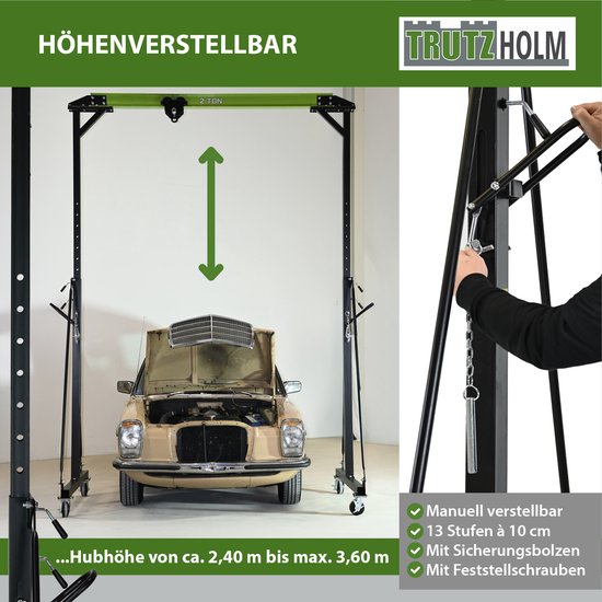In hoogte verstelbare portaalkraan 'HÖHENVERSTELLBAR' met een oude auto eronder. Handmatig verstelbaar van 2,4 m tot 3,6 m.