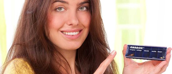 Femme aux cheveux bruns désigne une boîte à pilules Anabox rose à quatre compartiments.