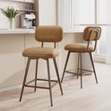Twee bruine barkrukken met metalen frame en leren zittingen in een keukeninterieur.